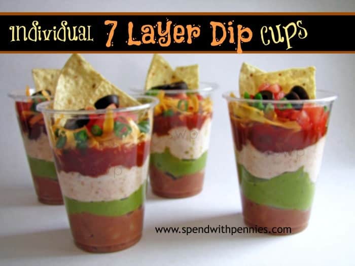 individual seven layer dip in cups with a tortilla chip