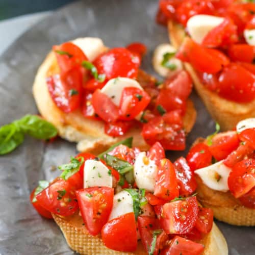 Several pieces of Caprese Bruschetta on a gray plate