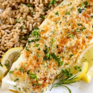 Parmesan Broiled Tilapia on a white plate with brown rice on the side