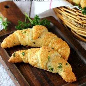 two garlic parmesan crescents on a wood board