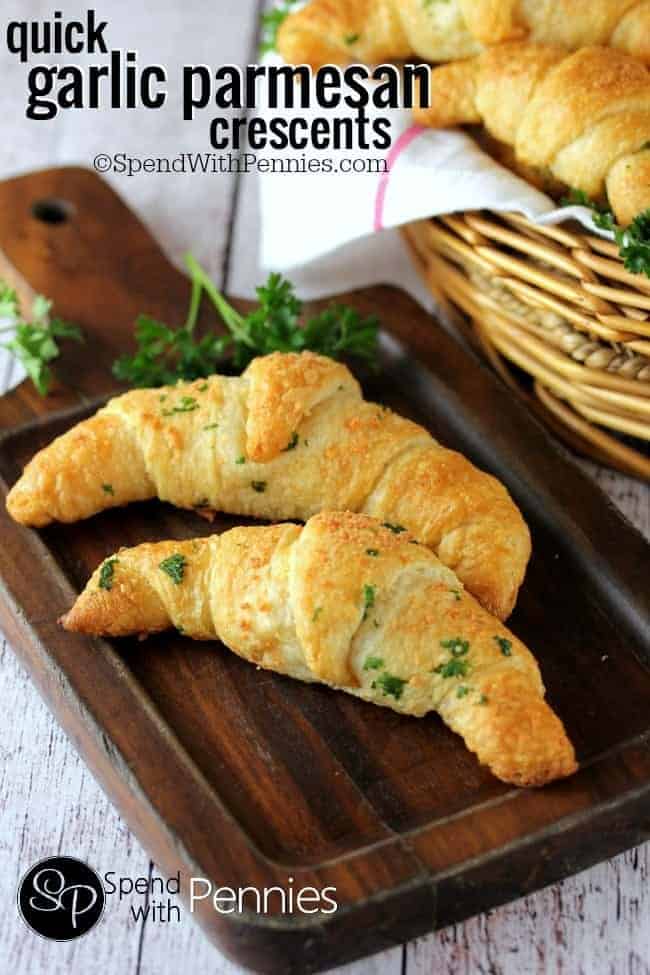 two garlic parmesan crescents on a wood board