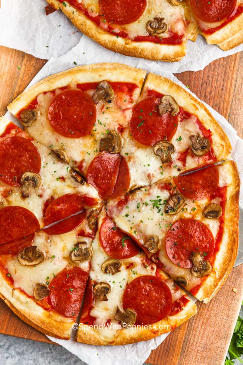 overhead view of a tortilla pizza with pepperoni and mushrooms