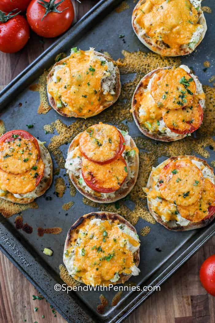 Tuna Melts on English muffins with cheddar cheese and tomatoes on a baking pan