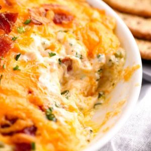 Bacon Cheddar Dip in a dish with crackers on the side