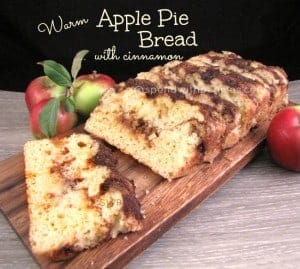 warm apple pie bread sliced on a wood board with apples on the side