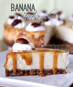 a slice of banana cheesecake topped with whipped cream and pecans with the whole cheesecake in the background