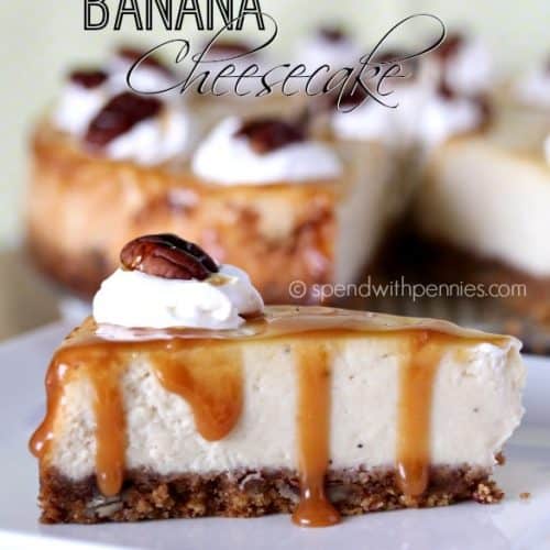 a slice of banana cheesecake topped with whipped cream and pecans with the whole cheesecake in the background