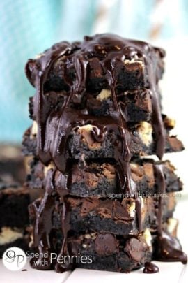 close up of a stack of Death By Chocolate Magic Cookie Bars topped with fudge sauce