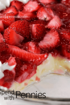 close up of fresh strawberries and cream pie with a slice out of it