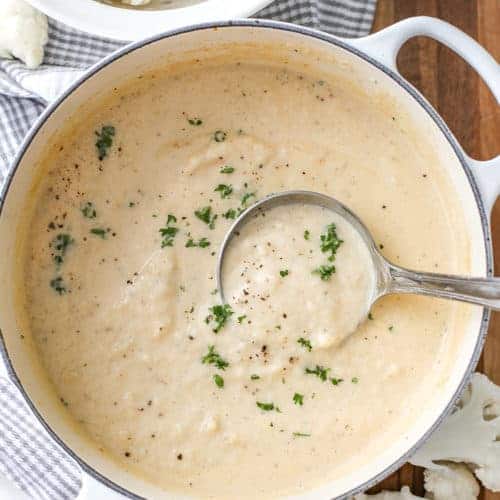 Overhead shot of Creamy Cauliflower Soup in a pot with a ladle