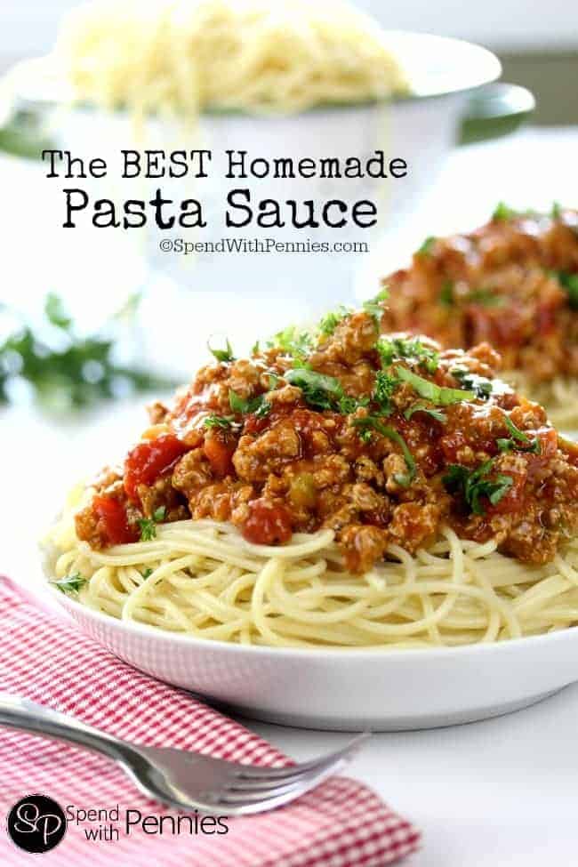 homemade pasta sauce on spaghetti, with a colander of spaghetti in the background