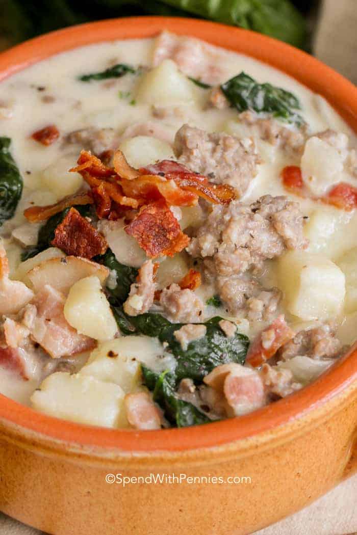 Zuppa Toscana is quick and easy Italian soup you can make at home! Loaded with sausage, potatoes and bacon, this hearty soup will definitely fill a hungry tummy! #spendwithpennies #zuppatoscana #easysoup #creamysoup #withspinach #withpotatoes #withbacon #heartysoup Homemade Zuppa Toscana served in a terra cotta bowl