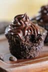 Chocolate cupcake with ganache on top with bite taken out of it