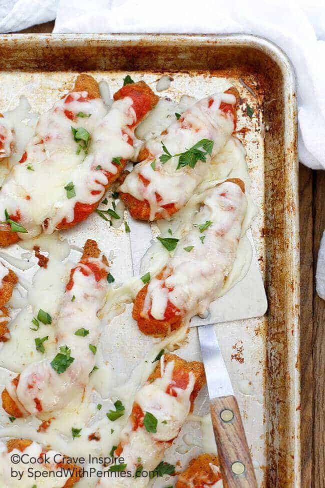 Chicken with tomato sauce and melted cheese being served with a spatual