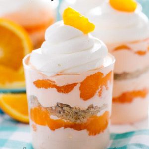 Creamsicle Parfaits with whipped topping and garnished with an orange slice with text