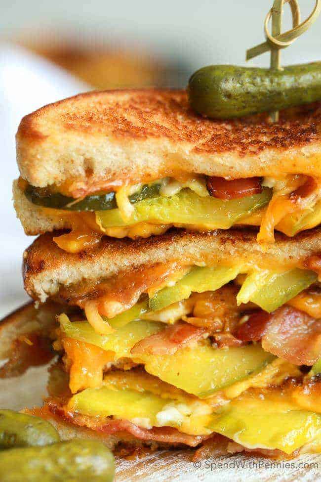 Stacked Dill Pickle Bacon Grilled Cheese with a pickle spear on top