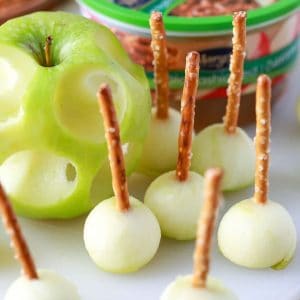 mini caramel dippers cut from an apple with pretzels in them