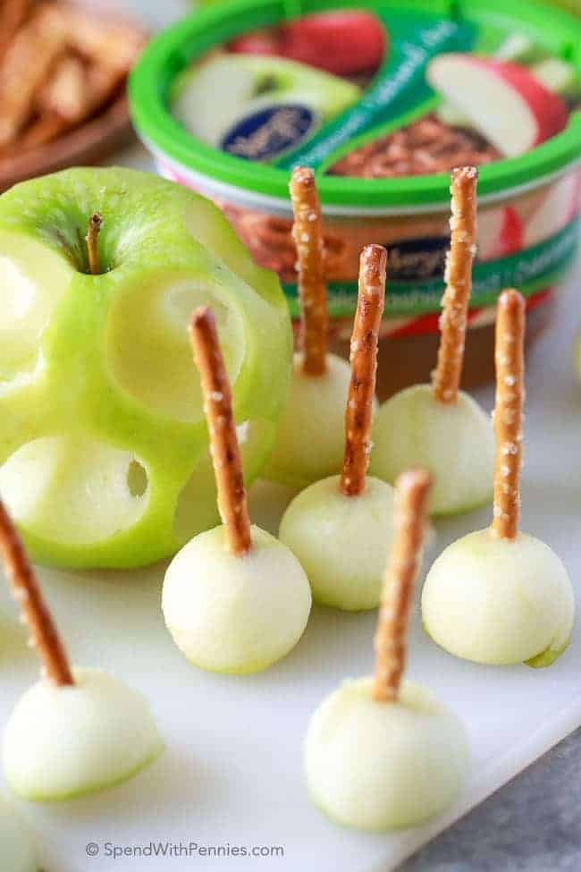 mini caramel dippers cut from an apple with pretzels in them
