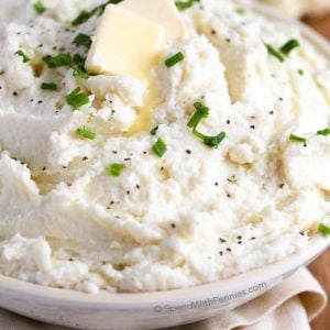 Mashed Cauliflower "Potatoes in a bowl with pats of butter