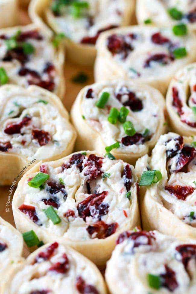 Cranberry Feta Pinwheels on a wood plate with green onion