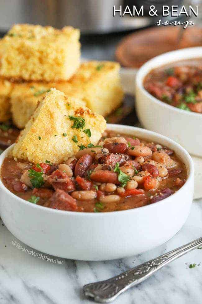 Crock Pot Ham and Bean Soup in a white bowl with cornbread