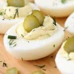 Cerca de Dill Pickle Deviled Eggs adornado con encurtidos y eneldo