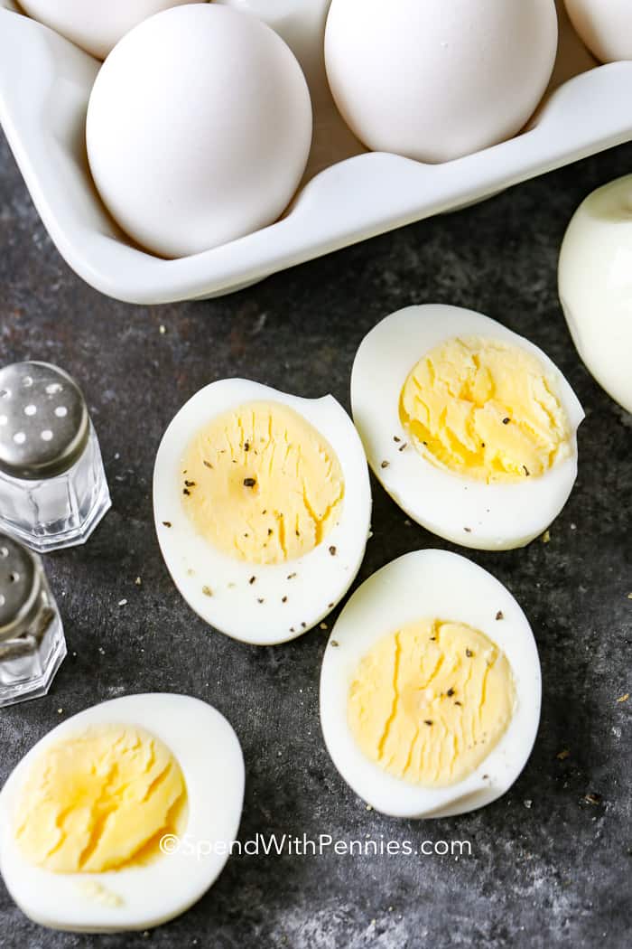 Hard Boiled Eggs are the base for an amazing snack, appetizer, or breakfast! So easy to make and convenient to keep on hand for last-minute guests or that mid-afternoon hunger attack! #hardboiledeggs #easy #eggs #spendwithpennies Two sliced hard boiled eggs