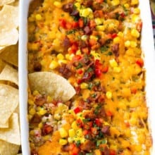 a chip in corn dip in a casserole dish