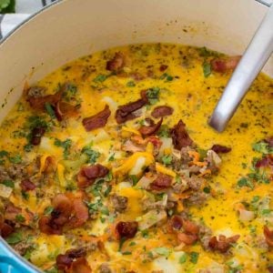 Bacon Cheeseburger Soup in a blue pot with a ladle