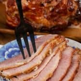 Slices of Baked Ham with Brown Sugar Glaze on a plate with a fork