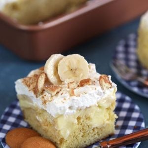 Banana Pudding Cake on a blue gingham plate with a copper fork.