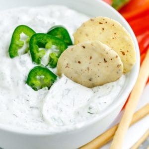 spicy dill dip with jalapeños in white bowl