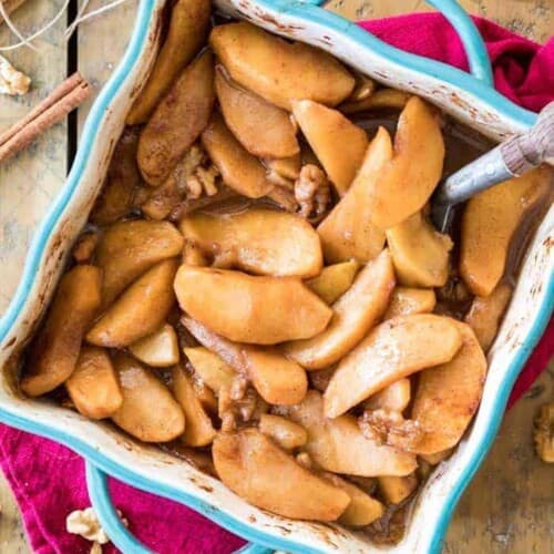 baked apple slices in a blue dish on wood