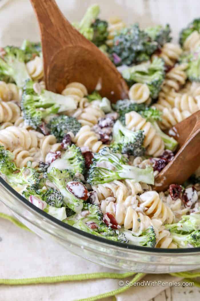 Broccoli Pasta Salad being stirred with two wooden spoons
