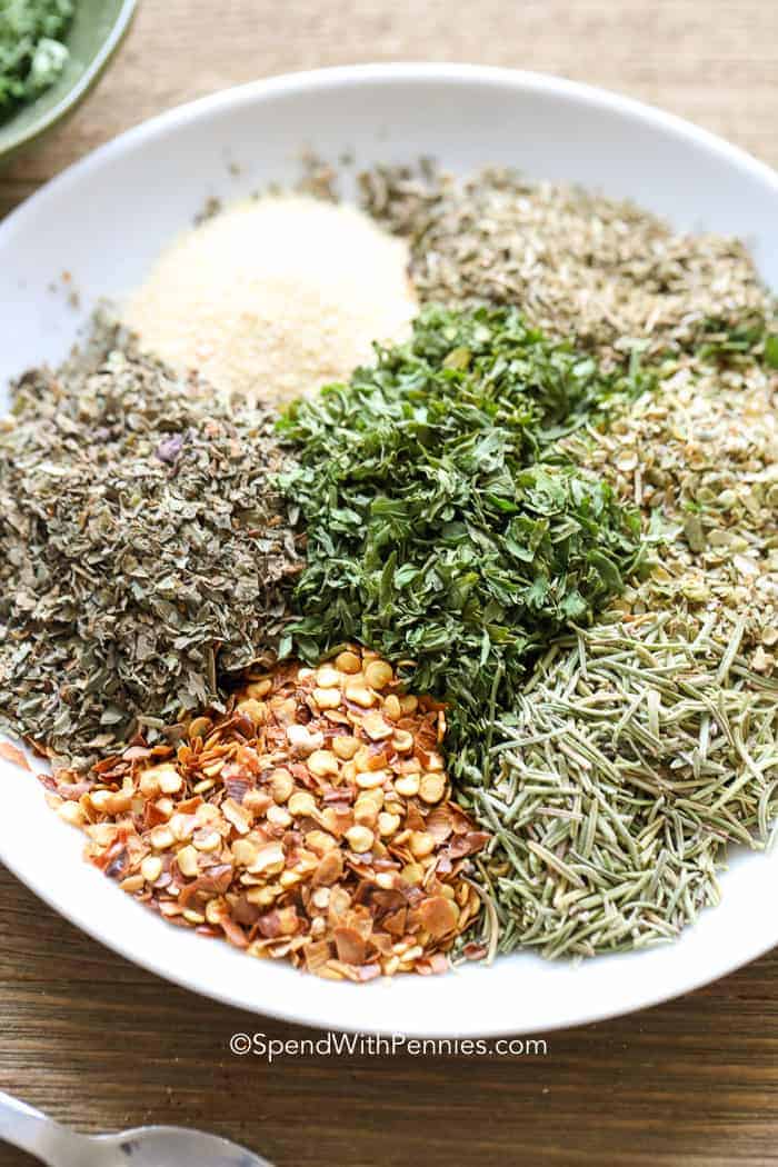Italian Seasoning is a mix of dried herbs and spices that adds a delightful touch to pasta sauces, marinades, and your favorite chicken, beef, or pork dishes. It's versatile, and great for grilled veggies, pizza, soups, and sauces, offering endless flavor possibilities! #italianseasoning #homemade #seasoning #spendwithpennies Italian Seasoning ingredients on a plate