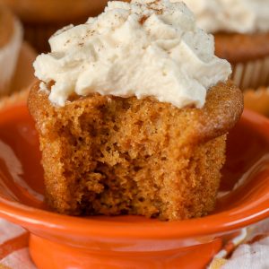 Pumpkin Cupcake on an orange dish with bite taken out of it