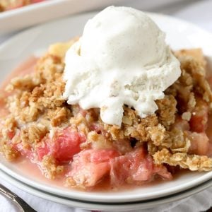 Rhubarb Crisp served on a white plate with ice cream on top