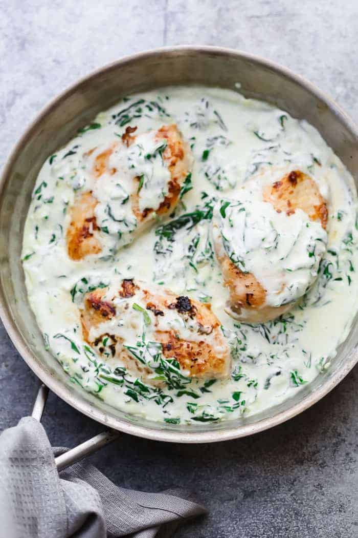 This comforting and creamy chicken florentine recipe is so delicious, and the whole family is sure to rave about it. It's ready in under 30 minutes but is easy, elegant, and ideal for company. The creamy sauce is savory, and rich and has a hint of tanginess from the wine and the cream cheese. This is just waiting to be served over pasta, rice, or potatoes. #spendwithpennies Creamy Chicken Florentine served straight off the heat in a pan