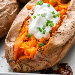 Baked Sweet Potato with sour cream on baking sheet