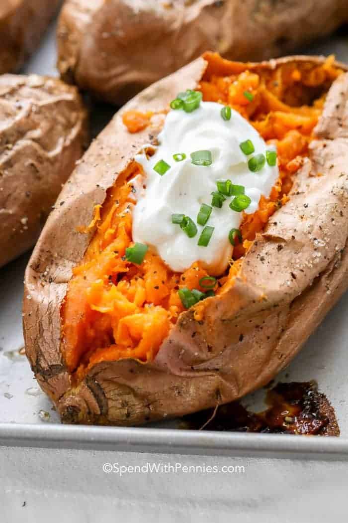 Baked Sweet Potato with sour cream on baking sheet