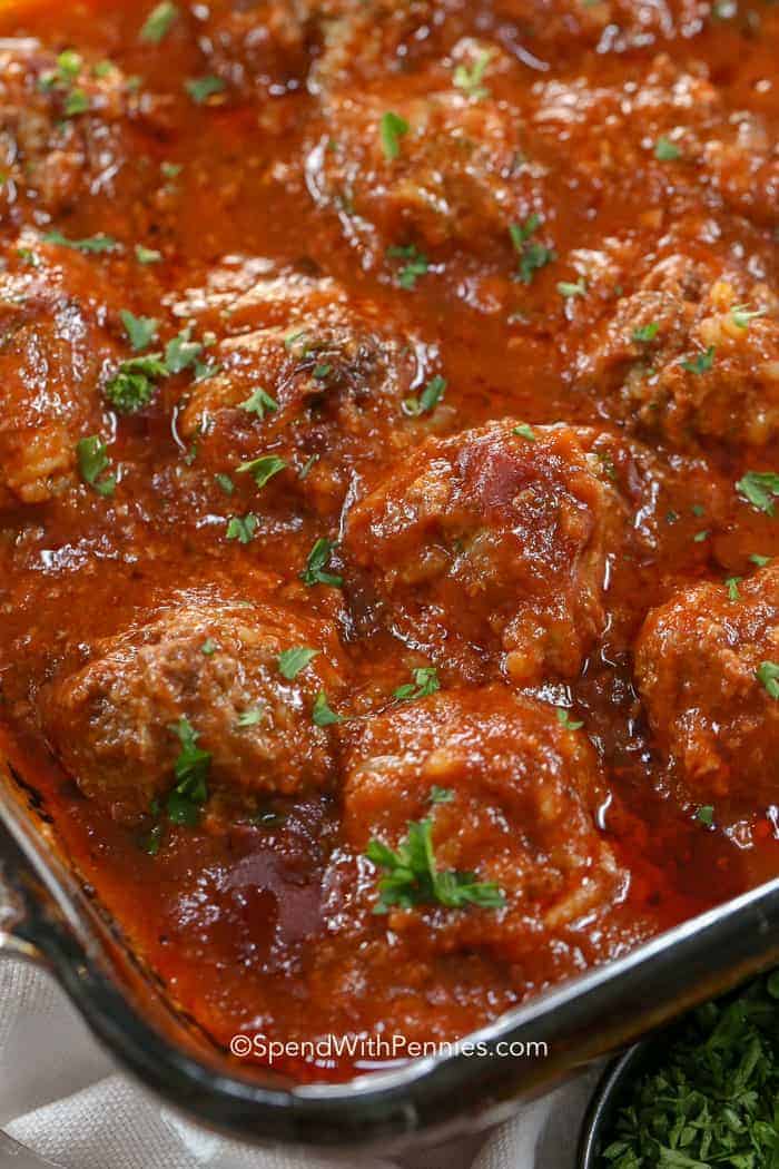 Porcupine meatballs are made with ground beef, rice, onion and seasonings then baked in a rich tomato sauce. So zesty and delicious, and ready in only an hour! #spendwithpennies Porcupine Meatballs in clear baking dish
