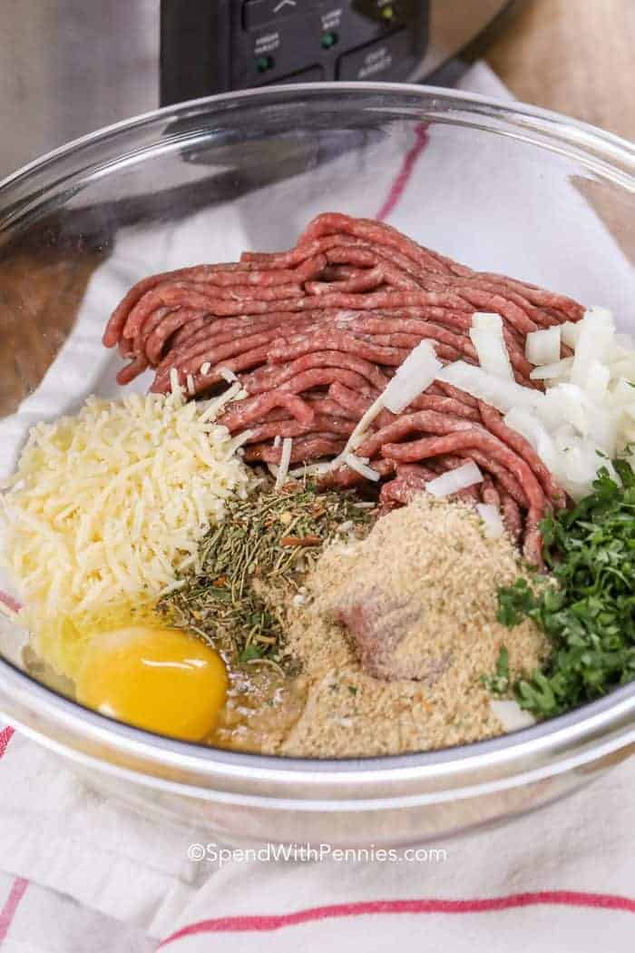 Meatball ingredients in clear glass bowl before mixing together