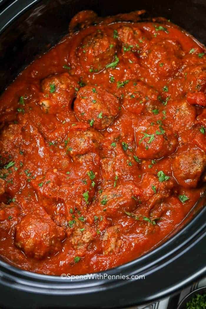 Meatballs cooking in black slow cooker