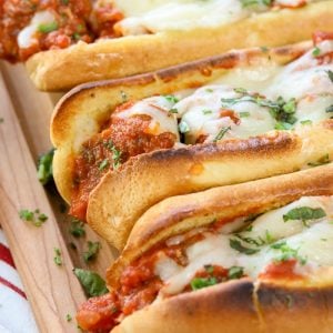 Three Meatball Subs on a wooden board