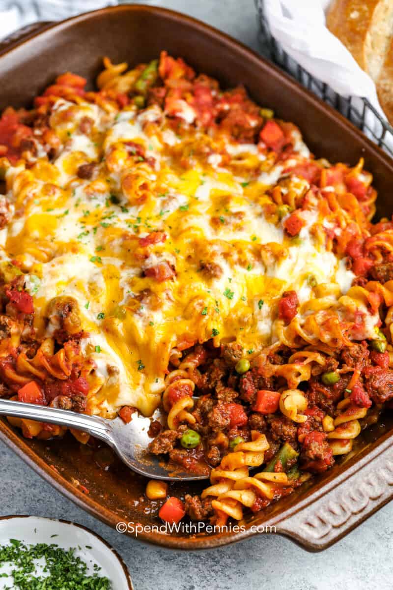 a casserole dish of baked hamburger casserole with a spoon