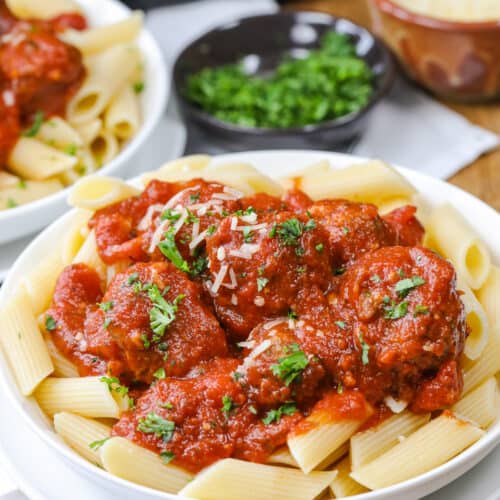 crock pot meatballs over pasta in a bowl with parsley