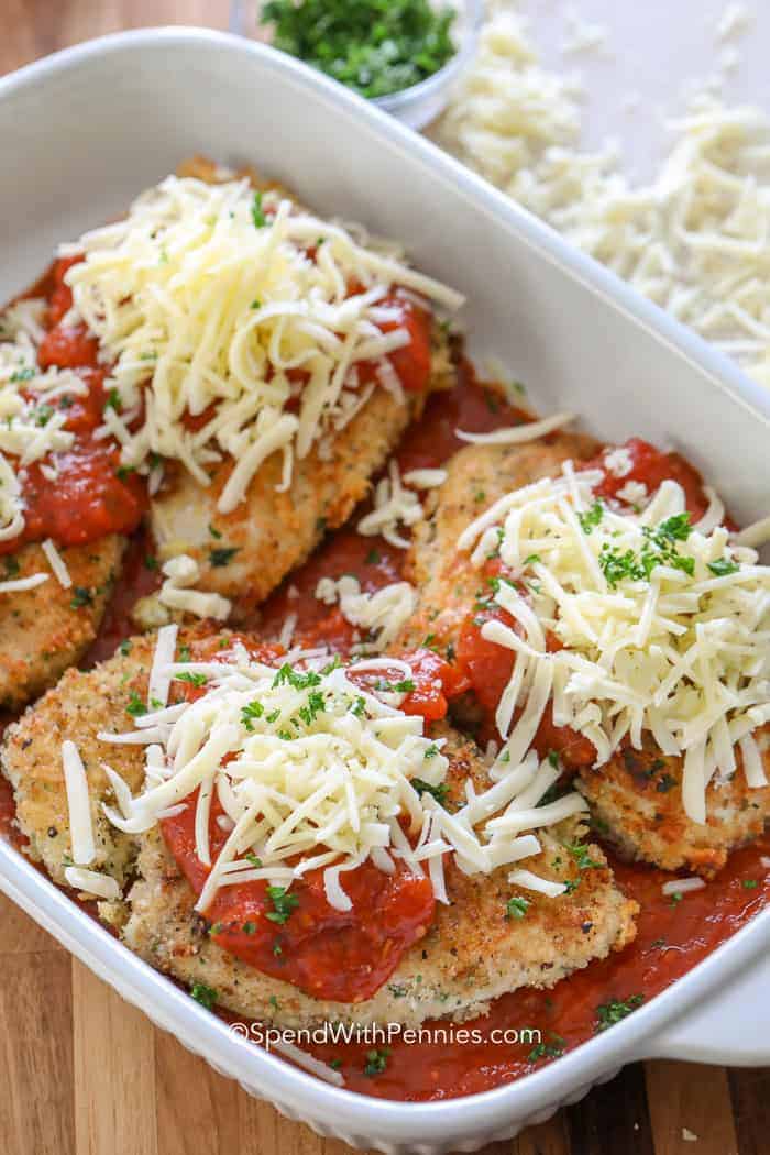 Classic chicken topped with Parmesan cheese and ready to bake in a baking dish