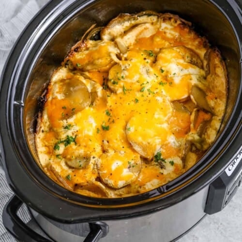 a slow cooker filled with crock pot scalloped potatoes
