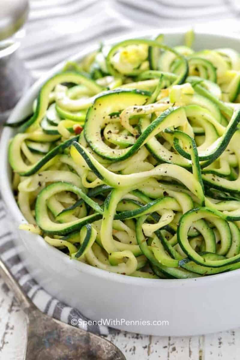 These zucchini noodles are the perfect addition to just about any meal. We love them as a substitution for just about any pasta dish! #spendwithpennies #lowcarb #zucchininoodles #noodles #zoodles #spiralizedzucchini A bowl of zucchini noodles seasoned with salt and pepper.