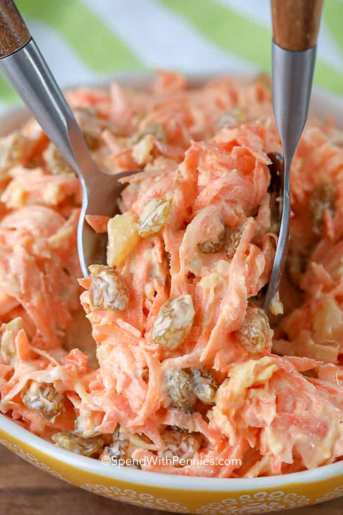 carrot salad being served with tongs